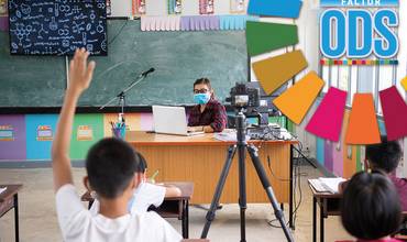 Un aula en la que un niño levanta la mano para participar