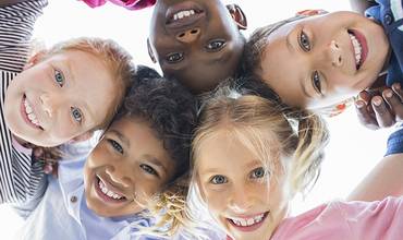 Un grupo de niños y niñas posan sonrientes para una foto