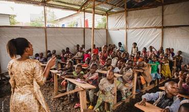 Un grupo de estudiantes asiste a clase en una escuela de RDC