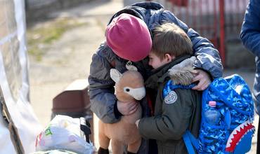 Anastasia consuela a su hermano Andrei, de seis años, mientras se preparan para salir de Rumanía hacia su próximo destino
