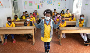 Una niña ejemplifica cómo guardar la distancia social en un colegio de Madagascar