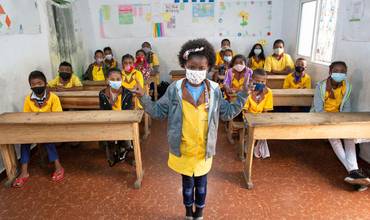 Una niña ejemplifica cómo guardar la distancia social en un colegio de Madagascar
