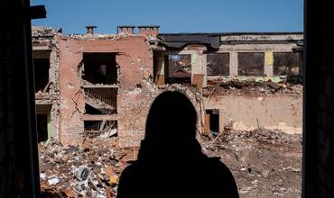 Una adolescente observa los restos una escuela que había servido como refugio civil y base logística antes de ser destruida por un ataque aéreo.