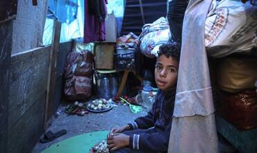 Mohammed, de 10 años, sentado en la tienda improvisada de su familia en un refugio para desplazados internos en Rafah.