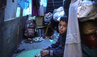 Mohammed, de 10 años, sentado en la tienda improvisada de su familia en un refugio para desplazados internos en Rafah.