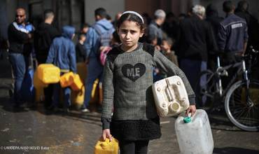 Una niña acude a recoger agua suministrada por UNICEF en la Franja de Gaza