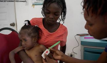 Una trabajadora sanitaria mide la circunferencia del brazo de una niña para conocer su nivel de desnutrición