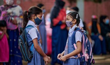 Dos amigas conversan después de conocerse en persona, un año después en la Escuela Primaria Gubernamental Gandaria Mohila Shomity, Dhaka, Bangladesh, el 12 de septiembre de 2021.