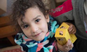Una niña sostiene cajas de suplementos nutricionales suministrados por una clínica apoyada por UNICEF en Siria.