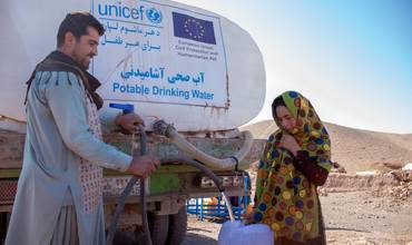 Una mujer afgana recoge agua potable suministrada por UNICEF mediante camiones cisterna