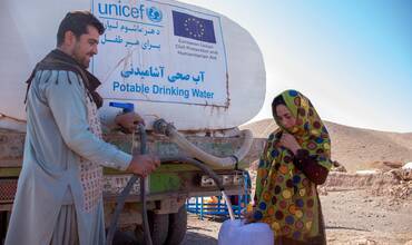 Una mujer afgana recoge agua potable suministrada por UNICEF mediante camiones cisterna