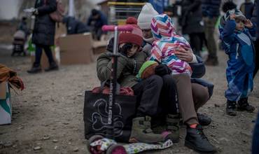 Una madre sentada con sus dos hijos después de llegar a Polonia desde Ucrania