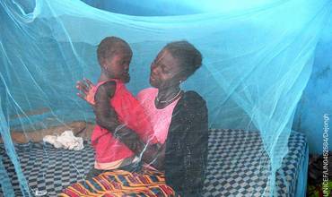 Una madre y su hija se protegen de los mosquitos bajo una red en Costa de Marfil