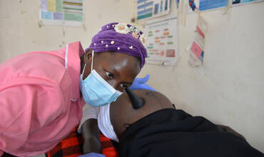 Una matrona examina a una mujer embarazada en Uganda