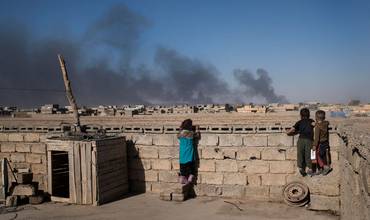 Unos niños observan a distancia el efecto de varias explosiones