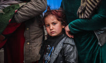 Niños y familias hacen cola frente a la clínica móvil de salud y nutrición de UNICEF 