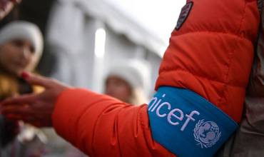 Un miembro del personal de UNICEF proporciona información a un grupo de personas refugiadas recién llegadas a Rumanía