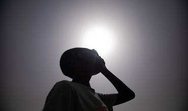 Ali, de 10 años, se protege el rostro del sol con la mano en Sudán
