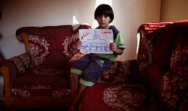 Un niño muestra un dibujo en Palestina