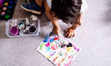 Un niño dibujando con acuarelas