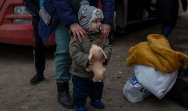 Un niño espera junto a su familia en un centro de recepción de personas refugiadas en la frontera entre Ucrania y Moldavia
