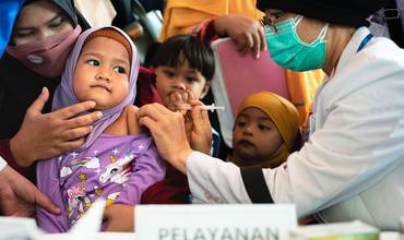 Una niña de tres años siendo vacunada en Indonesia
