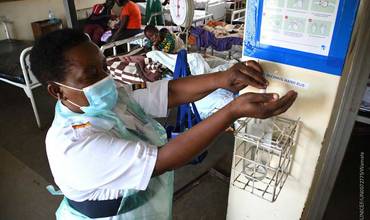 Una enfermera pediátrica se desinfecta después de atender a los pacientes en un hospital de Uganda