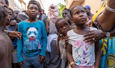 Niños desplazados por la guerra de bandas en Pont-Sondé, haciendo cola para recibir alimentos.