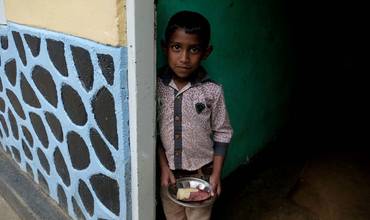 Un niño de Sri Lanka sostiene un plato de comida