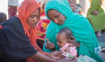 Personal humanitario mide la circunferencia del brazo de una niña pequeña en Sudán