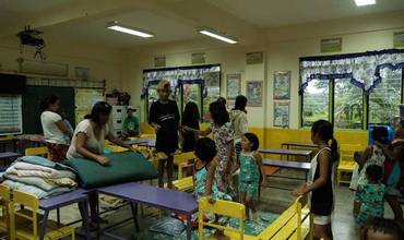 Residentes y familias que se alojan temporalmente en la Escuela Primaria Talao-Talao en Lucena, Filipinas.