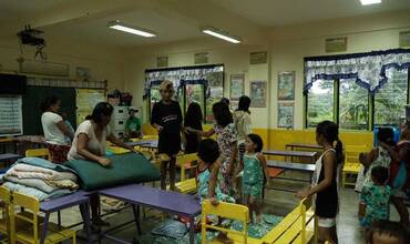 Residentes y familias que se alojan temporalmente en la Escuela Primaria Talao-Talao en Lucena, Filipinas.