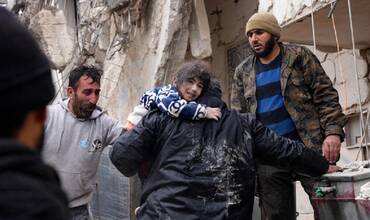Vecinos rescatan a un niño pequeño que había quedado entre los escombros en la ciudad de Afrin (Siria)