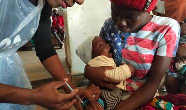 Personal sanitario vacunando a un bebé