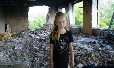 Una niña frente a las ruinas de su escuela en Ucrania
