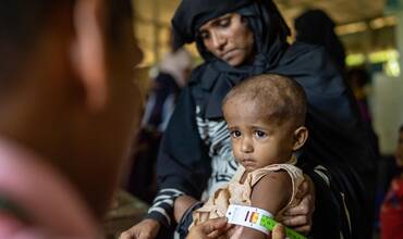 Evaluación de la desnutrición aguda de un niño en un campamento rohingya mediante una cinta MUAC.