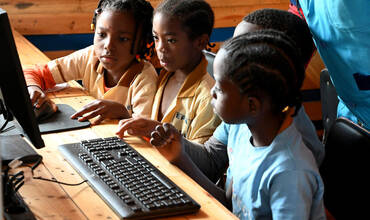 Niños aprendiendo con tablets y computadoras en una escuela pública de Camerún