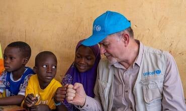 Ted Chaiban choca el puño con una alumna en la escuela Force Vives en Dori, Burkina Faso