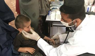 Un bebé es sometido a un chequeomédico en un campamento de desplazados en Afganistán