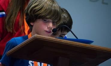 Un niño lee en un atril