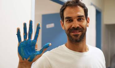 Jose Calderón con la mano pintada de azul colaborando con Unicef