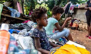 Una familia haitiana come en un refugio temporal