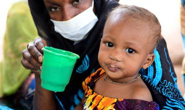 Una madre alimenta a su bebé en el este de Camerún