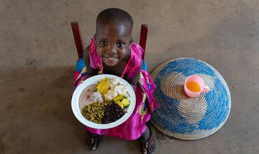 Nakalema Betty, de 3 años, se dispone a comer en Uganda