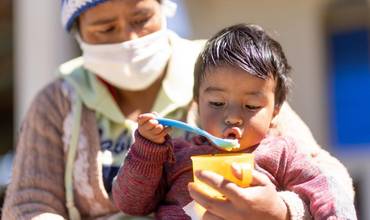 Niño alimentándose gracias al apoyo de las brigadas nutricionales