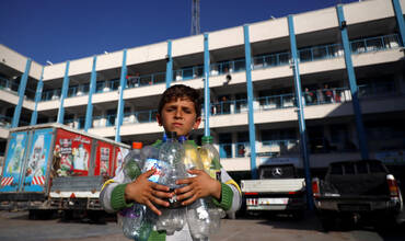 Un niño palestino con botellas vacias para llenarlas de agua