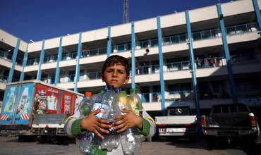 Un niño palestino con botellas vacias para llenarlas de agua