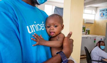 Imagen de un bebé en los brazos de un trabajador de UNICEF
