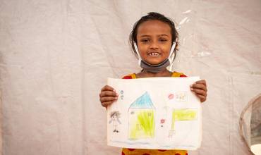 Una niña rohingya enseña un dibujo en Bangladesh