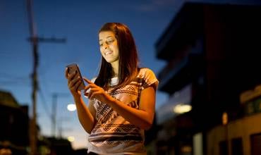 Imagen de una joven mirando su móvil